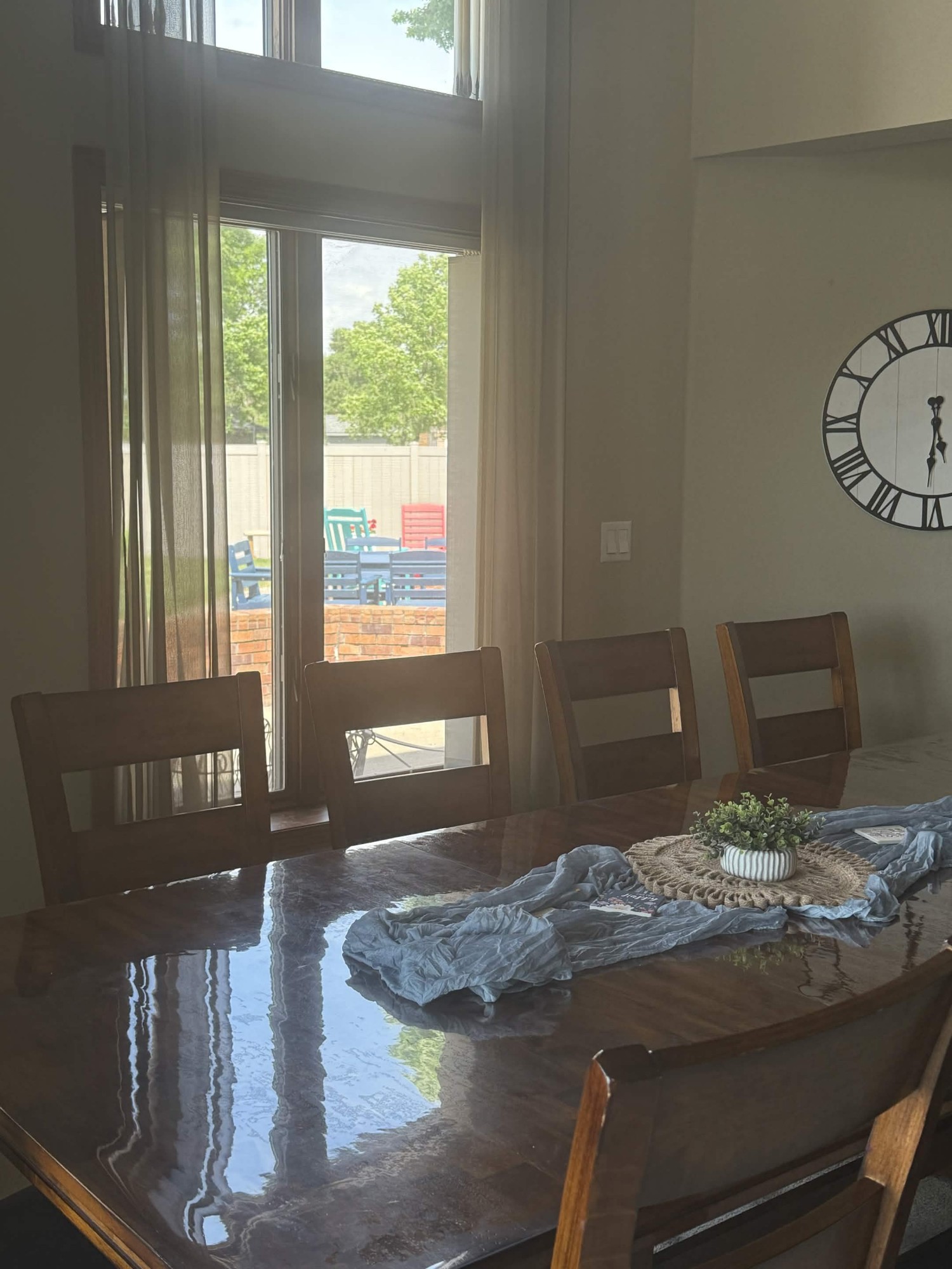Dining table with chairs by a window onto the patio
