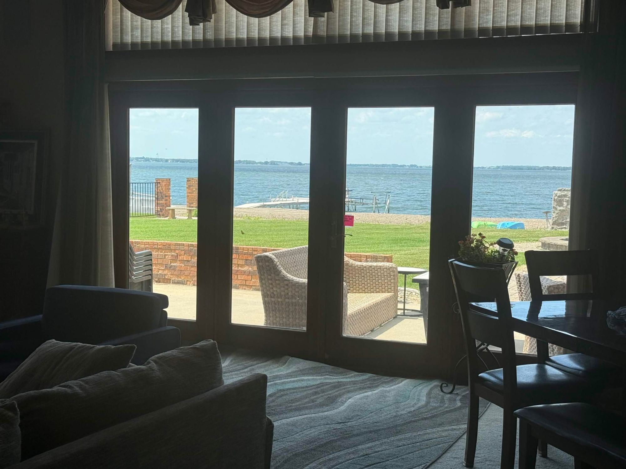 Great room glass doors looking out to the patio, lawn, dock and lake