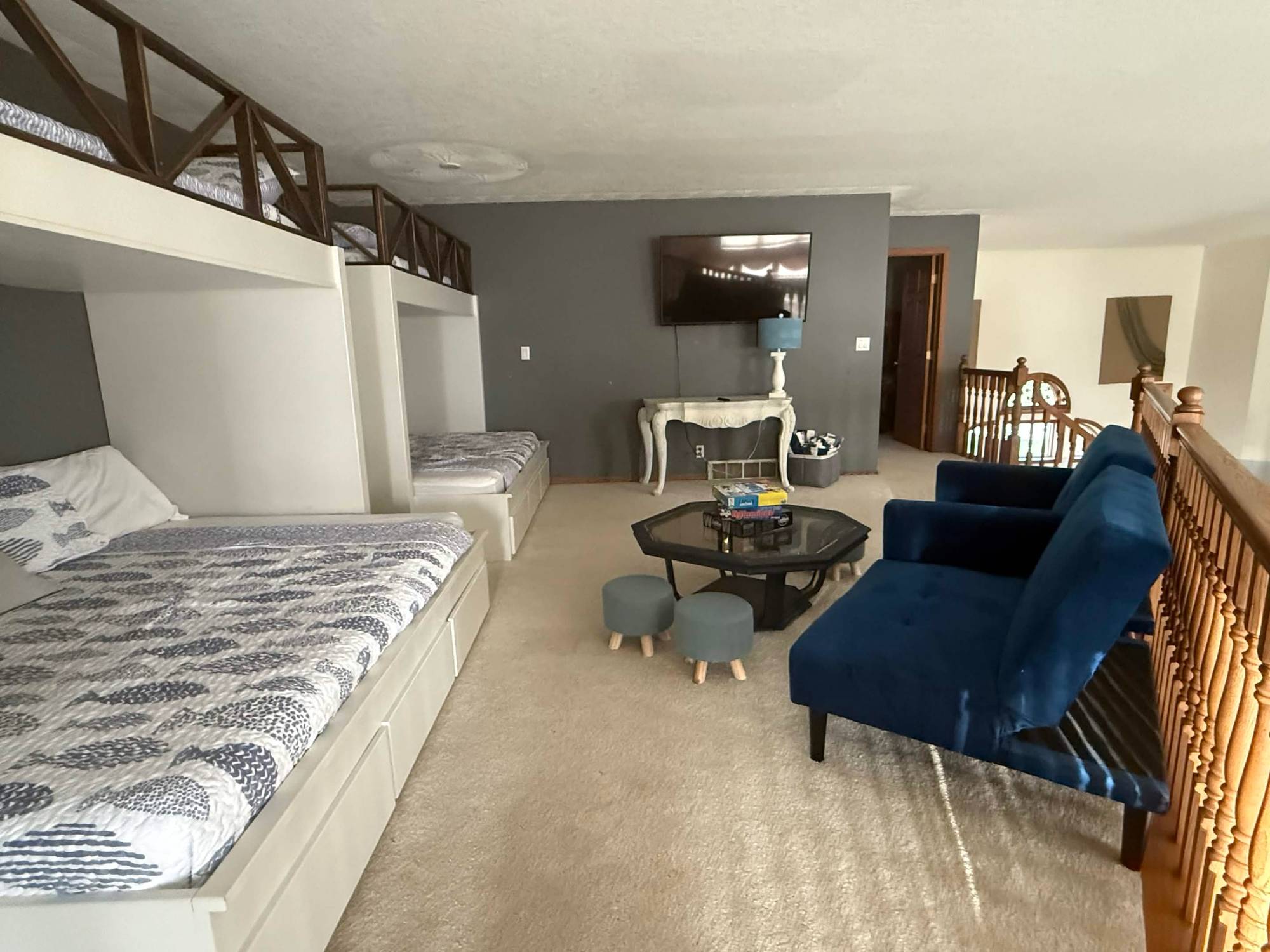 Upstairs loft with built-in bunks, TV and lounge chairs
