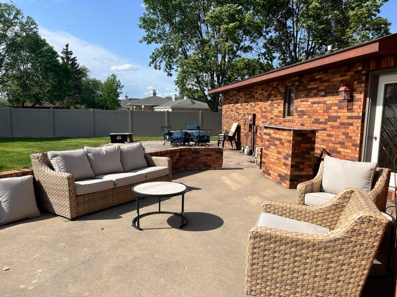 Patio with wicker sofa, outdoor bar and dining set